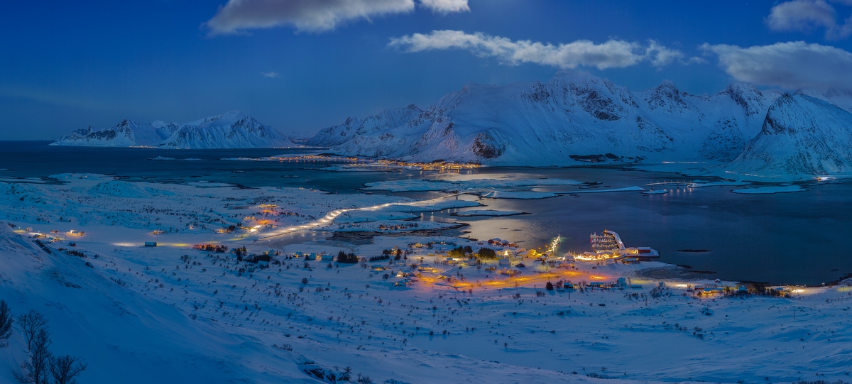 1,735 megapixels! A very high resolution, large-format VAST photo print of Lofoten, Norway at night with snow-covered mountains, illuminated homes, a bay, and the ocean; landscape photograph created by Martin Kulhavy in Fredvang, Lofoten, Norway.