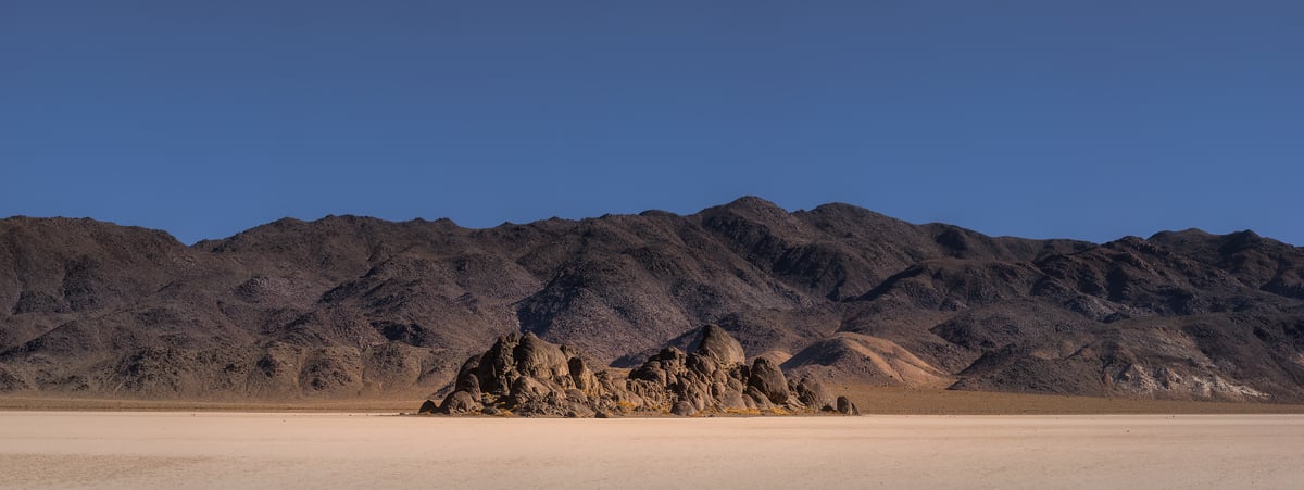 412 megapixels! A very high resolution, large-format VAST photo print of a minimalist landscape scene with a blue sky, some rocky hills, and a desert; landscape photograph created by Chris Blake in Death Valley National Park, California