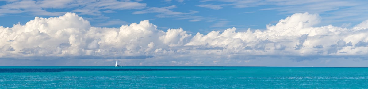319 megapixels! A very high resolution, large-format VAST photo print of a beautiful seascape with calm turquoise ocean water, a sailboat sailing in the distance, and puffy white clouds in a blue sky; panorama seascape photograph created by Assaf Frank in St John's, Antigua and Barbuda.