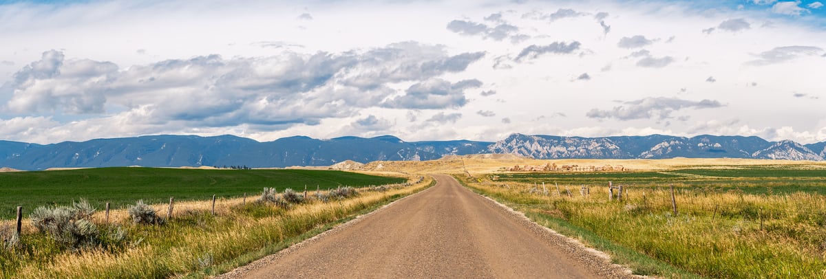 354 megapixels! A very high resolution, large-format VAST photo print of the Bighorn Mountains with a country road in the foreground running towards the mountains with fields on either side; landscape photograph created by Jerred Zegelis in Wyoming.